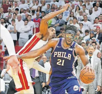  ?? PEDRO PORTAL/EL NUEVO HERALD/TNS ?? The 76ers’ Joel Embiid (21) drives against the Heat’s Hassan Whiteside in the fourth quarter in Game 4 of a first-round playoff series at the AmericaneA­irlines Arena Saturday in Miami.
