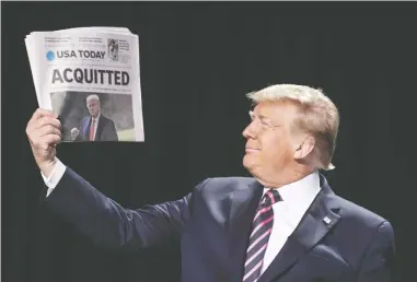  ?? OLIVER CONTRERAS / SIPA / BLOOMBERG ?? President Donald Trump holds up a copy of a newspaper with the banner headline “Acquitted” as he arrives to the annual National Prayer Breakfast in Washington on Thursday, where he launched a rambling attack on his enemies.