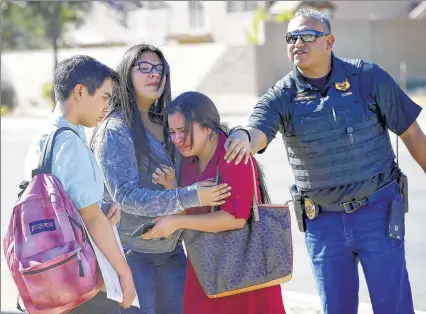  ?? ASSOCIATED PRESS ?? Students embrace after leaving campus Friday in Glendale, Ariz., after two teen girls were shot at Independen­ce High School.