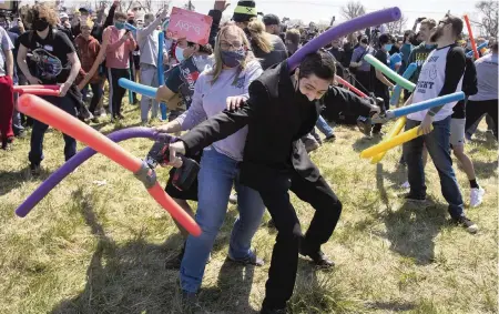  ?? KENNETH FERRIERA Lincoln Journal Star/AP ?? Dozens of people named Josh duke it out with pool noodles to determine the rightful owner of the name. The event in Lincoln, Neb., started as a joke during the pandemic, then came to life after the idea went viral on social media.