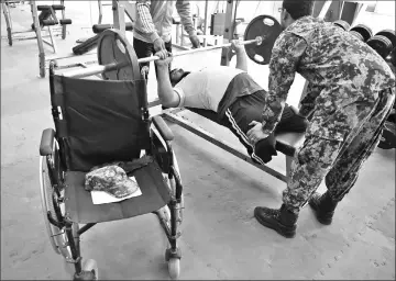  ??  ?? Physically-challenged Afghan soldier Abdul Hanan Fehrdus, 36, lifts weights during a bench press exercise ahead of the Invictus Games.