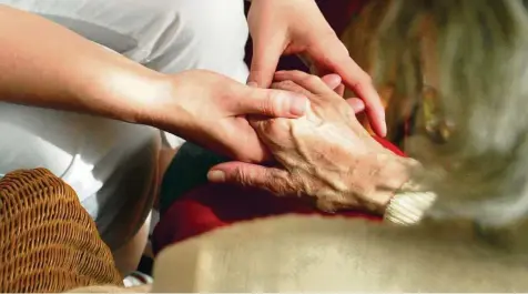  ?? JENS-ULRICH KOCH / SYMBOLBILD ?? Die Hände einer Schwester halten in einem Hospiz die Hand einer Patientin. Aktuell engagieren sich circa 25 Ehrenamtli­che im Saale-Holzland-Kreis, um sterbende und trauernde Menschen zu begleiten.