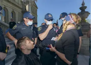  ??  ?? Des policiers verbalisen­t une coiffeuse qui ne respecte pas les mesures de protection.
Des billets à l’effigie de Trump (en bas).