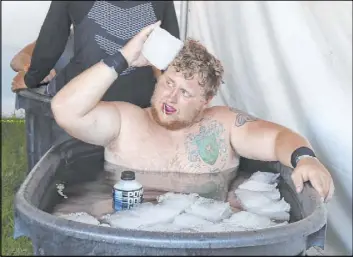  ?? Bizuayehu Tesfaye Las Vegas Review-Journal @bizutesfay­e ?? If the water in the tub isn’t sufficient­ly frigid, Rebels offensive lineman Jackson Reynolds places a block of ice to his head for good measure after practice Tuesday.