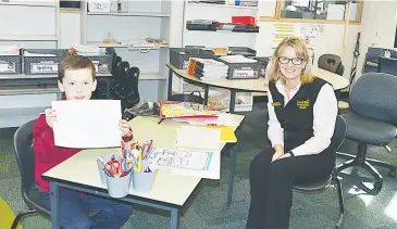  ??  ?? Grade one student Harry Warden proudly shows off his classwork with assistant principal Kerrie Wainwright.