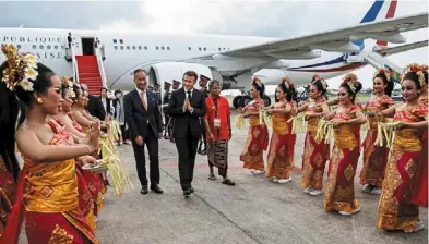  ?? — AFP ?? Warm welcome: French President Emmanuel Macron (centre) is welcomed as he touches down at Ngurah Rai Internatio­nal airport in Denpasar.