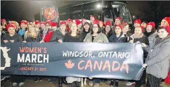  ?? NICK BRANCACCIO ?? Dozens of local women hold up a banner on Jan. 20, 2017, before boarding a bus in South Windsor to attend the Women’s March on Washington protest. This year, Women’s March Canada is holding events across the country Jan. 20, including a march in Windsor.