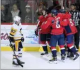  ?? NICK WASS — THE ASSOCIATED PRESS ?? Pittsburgh’s Sidney Crosby, left, skates by as the Capitals, including Alex Ovechkin and Evgeny Kuznetsov, celebrate a goal by right wing T.J. Oshie, second from left, during the third period on Wednesday in Washington. The Capitals won 2-1.