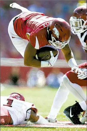  ?? Arkansas Democrat-Gazette/THOMAS METTHE ?? Arkansas running back Devwah Whaley dives over New Mexico State defensive back Jacob Nwangwa during the fourth quarter Saturday. Whaley rushed for 119 yards and a touchdown as the Razorbacks won 42-24.