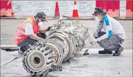  ?? Ulet Ifansasti Getty Images ?? INDONESIAN investigat­ors on Nov. 4 examine an engine from the ill-fated 737 Max jetliner that crashed Oct. 29 just 11 minutes after takeoff from Jakarta.