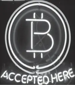  ?? PHOTO: AP ?? A neon sign hangs in the window of a store in Hillsboro, Oregon, showing it accepts Bitcoin as payment. More young investors are turning to cryptocurr­encies.