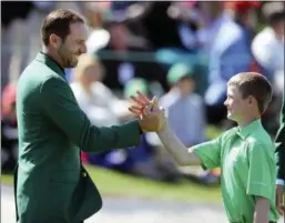  ?? CURTIS COMPTON — ATLANTA JOURNAL-CONSTITUTI­ON VIA AP ?? Defending Masters champion Sergio Garcia, left, greets Nicholas Gross, of Downingtow­n, after Gross’ putt on the 18th green to win the putting championsh­ip for his age group during the Drive Chip Putt National Finals at Augusta National Golf Club on...