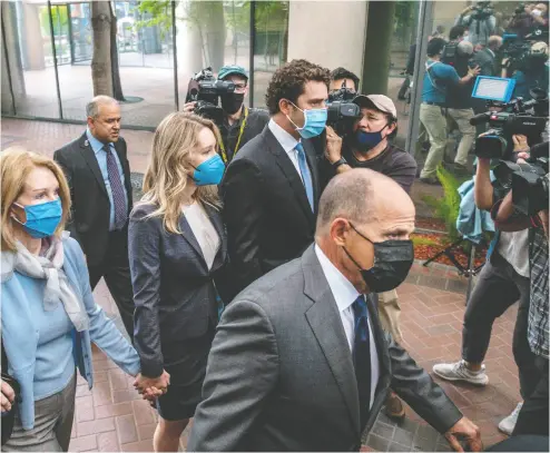  ?? NICK OTTO / AFP VIA GETTY IMAGES ?? Elizabeth Holmes, second from left, the founder and former CEO of blood testing and life sciences company
Theranos, arrives Wednesday for the first day of her fraud trial, outside federal court in San Jose, Calif.