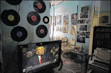  ?? RAMON ESPINOSA / AP ?? A television set shows U.S. President Donald Trump announcing his new Cuba policy, in a living room decorated with images of Cuban leaders at a house in Havana, Cuba, Friday.