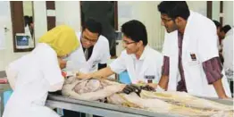  ??  ?? Students dissecting a human cadaver.