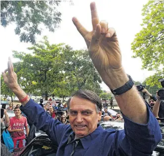  ?? WILTON JUNIOR/ESTADÃO ?? Bolsonaro. Candidato saúda fãs após votar em escola no bairro da Vila Militar, no Rio