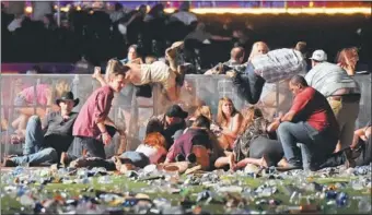  ?? DAVID BECKER / GETTY IMAGES VIA AFP ?? Concertgoe­rs scramble for shelter at the Route 91 country music festival after gunfire breaks out on Sunday in Las Vegas.