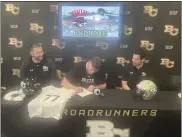  ?? JUSTIN COUCHOT — ENTERPRISE-RECORD ?? Butte College left tackle Michael Bareman, center, signs his letter of intent to University of Nevada Las Vegas alongside Butte head coach Robby Snelling, left, and offensive line coach Jacob Vazquez on Friday at Butte College.