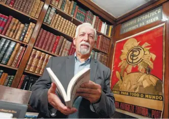  ??  ?? Alfarrabis­ta Nuno Canavez, de 83 anos, vive rodeado de livros desde os 13