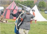  ?? ?? Re-enactors demonstrat­e the art of combat in Viking times.