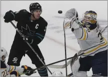  ?? JEFF CHIU — THE ASSOCIATED PRESS ?? Despite a 4-3 loss to Buffalo on Saturday, Sharks coach Peter DeBoer saw the identity he’s been waiting for since the beginning of the season. Here, Sabres goalie Linus Ullmark reaches for the puck next to the Sharks’ Logan Couture.