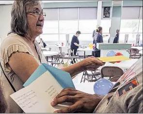  ?? Arkansas Democrat-Gazette/MITCHELL PE MASILUN ?? Rosemary Holloway with the Little Rock Compassion Center hands out birthday cards to people waiting in line for food Saturday during a party in their honor.