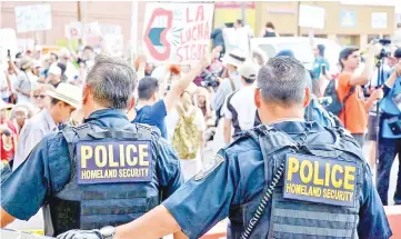  ??  ?? Homeland Security police officers watch over protesters at the Paso Del Norte port of entry, an internatio­nal bridge connecting Juarez, Mexico in downtown El Paso,Texas, US. — Reuters photo