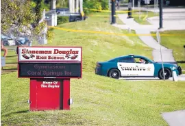  ?? WILFREDO LEE/ASSOCIATED PRESS ?? Law enforcemen­t officers block off the entrance to Marjory Stoneman Douglas High School, in Parkland, Fla., a day after 17 people were killed there.