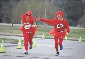  ?? PHOTOS BY KIM ODOM/SPECIAL TO THE WEEKLY ?? Sara Nerhing was met by her dad, Bruce McHaney, near the finish line with big cheers and applauds. Top: Sweetheart­s, Bruce and Faye McHaney, gave each other a kiss for luck before the race on Feb. 11, at the annual Valentine’s Day 5K and 10K Walk & Run...