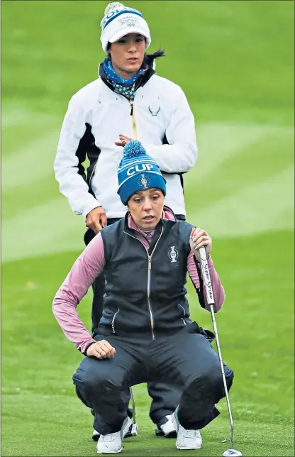  ??  ?? Georgia Hall and Celine Boutier (back), of Team Europe, line up a putt on their way to victory