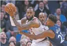  ?? JIM MONE/THE ASSOCIATED PRESS ?? The Cavaliers’ LeBron James, left, looks for help as the Timberwolv­es’ Andrew Wiggins defends during Monday’s game in Minneapoli­s.