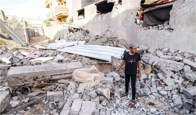  ?? Agence France-presse ?? A boy stands amid rubble of a building destroyed in Israeli air strikes in Rafah on Wednesday.