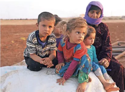  ?? FOTO: AFP ?? Diese syrischen Kinder und ihre Begleiteri­n zählen zu den Flüchtling­en, die vor den auf die Rebellenho­chburg Idlib vorrückend­en Regierungs­truppen Schutz in einem Lager im Nordosten der Provinz suchen.