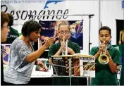  ?? BRUCE R. BENNETT / THE PALM BEACH POST ?? North Palm Beach Elementary teacher Tammy Rawls (left) directs fifif th- graders Ruby Dunn and Marcus Joseph on Tuesday at the “Showcase of Schools” at the South Florida Fairground­s.