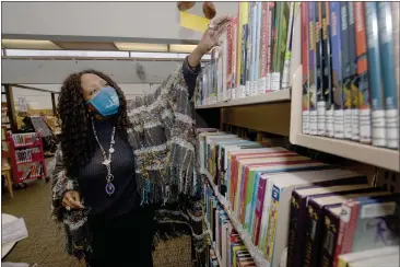  ?? SHERRY LAVARS — MARIN INDEPENDEN­T JOURNAL ?? Stephanie Hartwell-Mandella, manager of the Corte Madera Library, works in the children’s section on Wednesday. She said the offer to pay the overdue fines on a children’s book taken out in 1972 was “a wonderful surprise.”