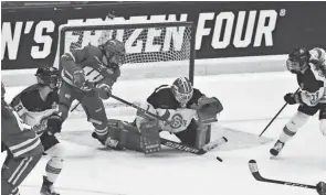  ?? MARK STEWART/MILWAUKEE JOURNAL SENTINEL ?? Wisconsin's Kelly Gorbatenko reaches for the puck as Ohio State goalender Raygan Kirk makes a save during the NCAA women's hockey national championsh­ip game on Sunday.