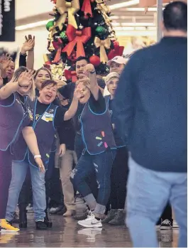  ?? ROBERTO E. ROSALES/JOURNAL ?? ABOVE: Walmart employees were excited to greet customers Thursday at the reopening of the El Paso store that had been closed since a mass shooting in August.
LEFT: El Paso resident Mayra Paz brought her two children to the reopening of the Walmart that had been closed since August 3.