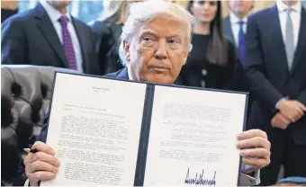  ?? EVAN VUCCI, AP ?? President Trump shows off his signature on an executive order about the Dakota Access pipeline. On energy policy, Trump has acted through executive orders rather than go through Congress.