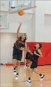  ??  ?? Jacksonvil­le senior Alexis Smith, left, attempts a layup while junior Alexis Rowe watches.