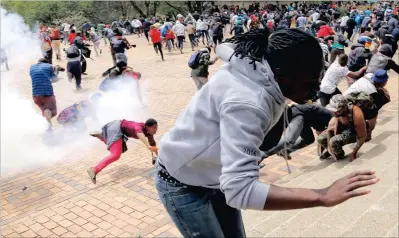  ?? PICTURE: EPA ?? Students from Wits University are thrown to the ground after a stun grenade exploded near them during running battles on the campus as ongoing protests continued against the cost of higher education.