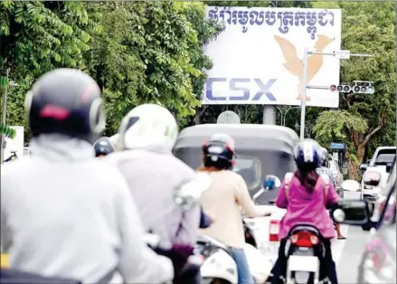  ?? HENG CHIVOAN ?? Traffic whizzes by a billboard advertisem­ent for the Cambodia Securities Exchange (CSX) in Phnom Penh in 2020.