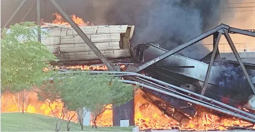  ??  ?? A derailed freight train burns on a bridge over Tempe Town Lake on Wednesday.