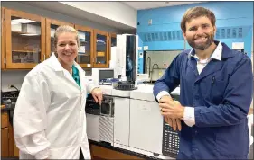  ?? Contribute­d photo ?? Lauren McDonald and her husband, Alex, pose in front of a Gas Chromatogr­aphMass Spectromet­er, one of several tools used to analyze chemical drug samples at the Arkansas State Crime Lab. McDonald, a 1998 Parkers Chapel graduate, originally intended to become a teacher and coach when she entered college at the University of the Ozarks, but after falling in love with chemistry, she studied forensics and is now the Chief Forensic Chemist at the state Crime Lab.