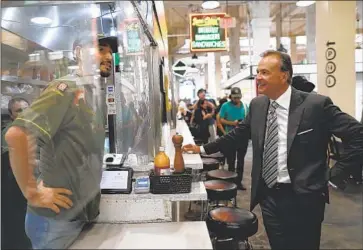  ?? Robert Gauthier Los Angeles Times ?? MARLIN MEDINA, left, greets L.A. mayoral candidate Rick Caruso at Grand Central Market on Thursday. Caruso’s nearly $34-million outlay as of last week was more than 11 times the expenditur­es by his main rival.