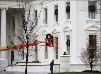  ?? The New York Times/AL DRAGO ?? Workers take down Christmas decoration­s at the White House on Friday. Aides said President Donald Trump was at the White House holding meetings and making calls. Office of Management and Budget Director Mick Mulvaney said that Trump had “canceled his plans for Christmas, and now he’s canceled his plans for New Year’s.”