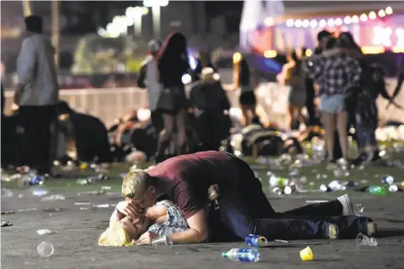  ?? David Becker / Getty Images ?? A man crouches over a woman on the ground in the panic. The photograph­er saw the man help the woman up and both get away.