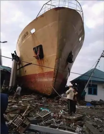  ?? RIO MARIO — THE ASSOCIATED PRESS ?? Villagers look at a ship Saturday that was swept ashore by a tsunami in Palu, Sulawesi island, on Friday.