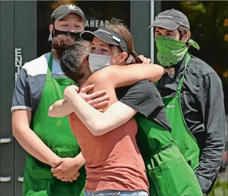  ?? SEAN D. ELLIOT/THE DAY ?? Marcela Lee embraces Isabella Persons on Thursday as fellow baristas Luke LePage, left, and Gavin Schriever look on at the Norwich Starbucks. Lee returned to thank the staff for backing her up in a racially charged incident. Go to theday.com to see a video.