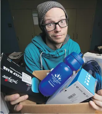  ?? BRIT TON LEDINGHAM ?? Jon Heath-Smith, community engagement co-ordinator for the Students’ Associatio­n of Mount Royal University, shows some of the random items delivered to the group. Amazon has launched a probe into the mystery sender of the parcels, which have been sent...