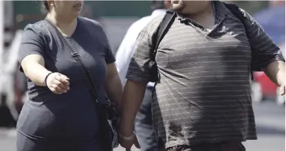  ?? EFE ?? Epidemia.
Dos personas con sobrepeso caminan en Ciudad de México, en México, una de las naciones de Latinoamér­ica con las tasas más elevadas de diabetes por obesidad. En esa nación buscan nuevos protocolos no invasivos, como una terapia que reduce el...